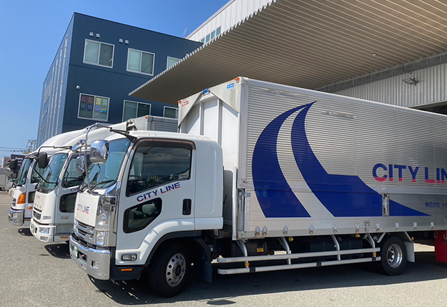 社屋前に並ぶトラックの写真