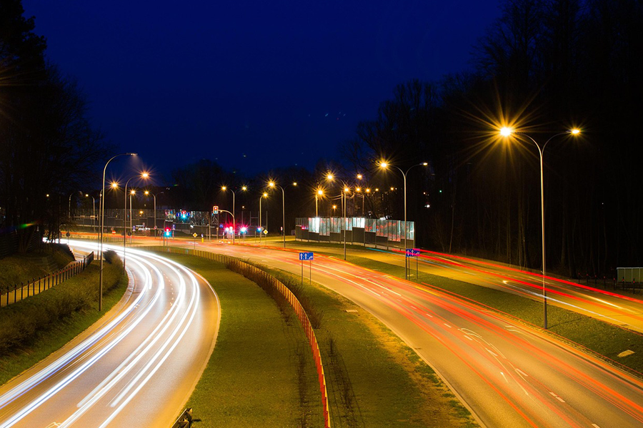夜の道路を走る車のライトの軌跡の写真