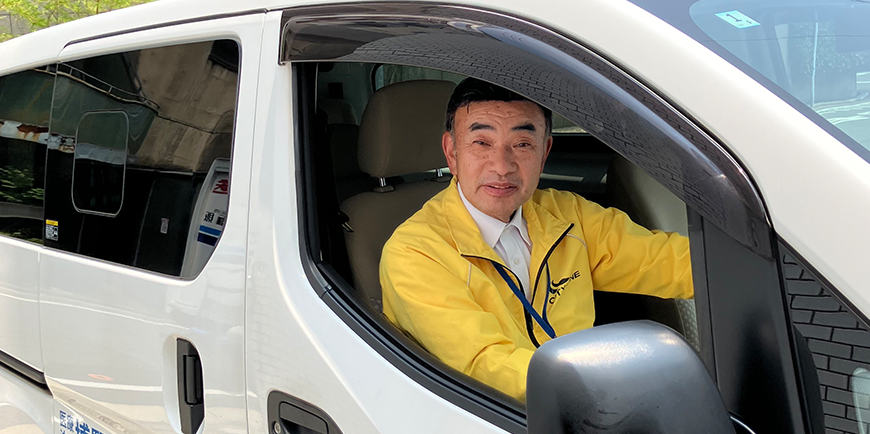 送迎車の運転席に座るスタッフ