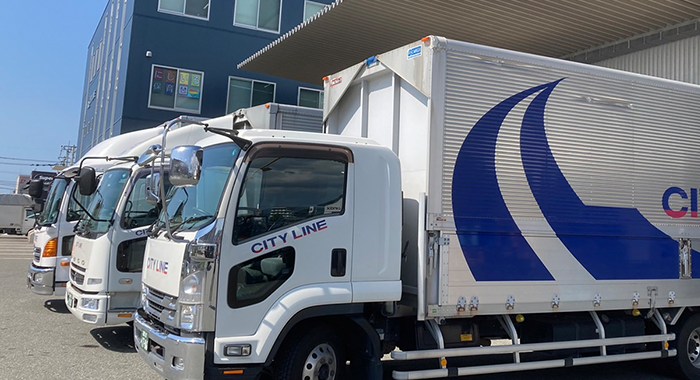 複数の配送トラックが並ぶ物流拠点の風景