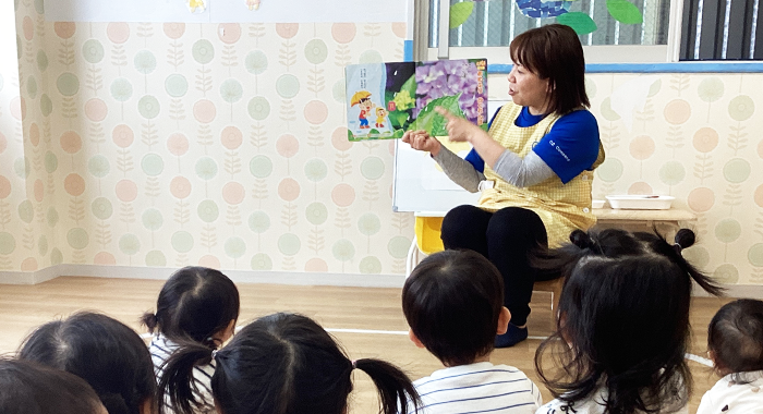 保育園で子どもたちに読み聞かせを行う保育士
