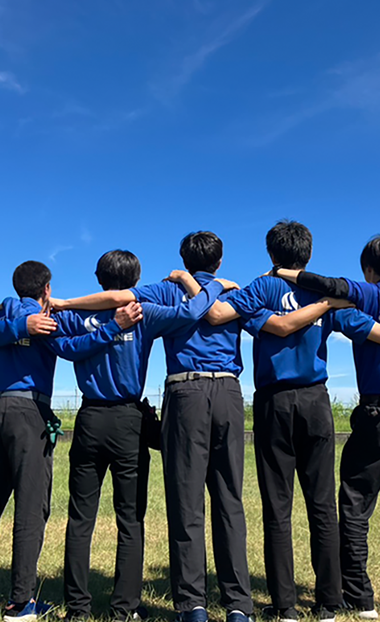 屋外で肩を組むスタッフの写真